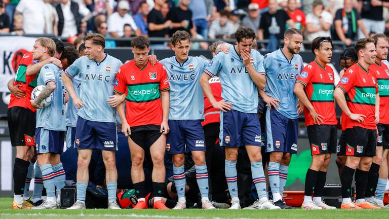 Spelers van NEC en Willem II staan om de geblesseerde Dirk Proper heen. (Foto: Broer van den Boom/Orange Pictures)