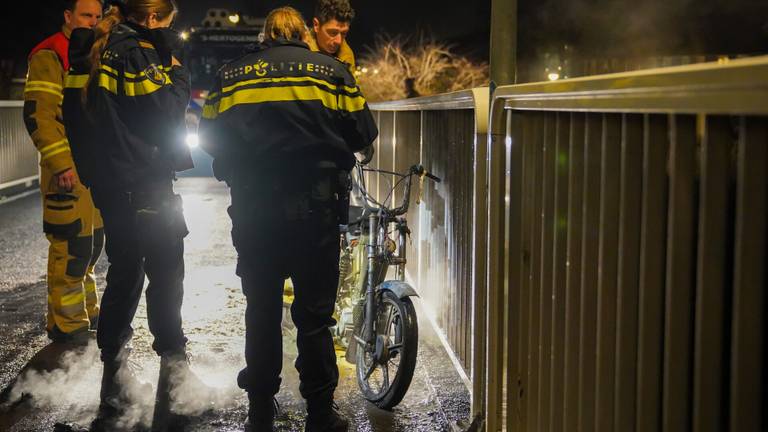 De politie en de brandweer bekijken de brommer (foto: Jurgen Versteeg/SQ Vision). 