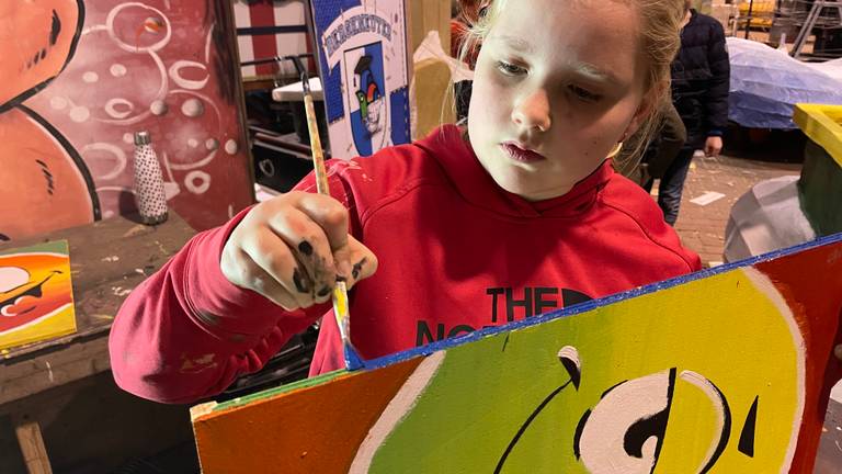 Suus (10) is druk aan het schilderen om te oefenen voor de carnavalswagen (foto: Alice van der Plas)