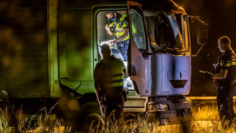 Agenten doen onderzoek bij de achtergelaten vrachtwagen op de A58 (foto: Jack Brekelmans/SQ Vision).