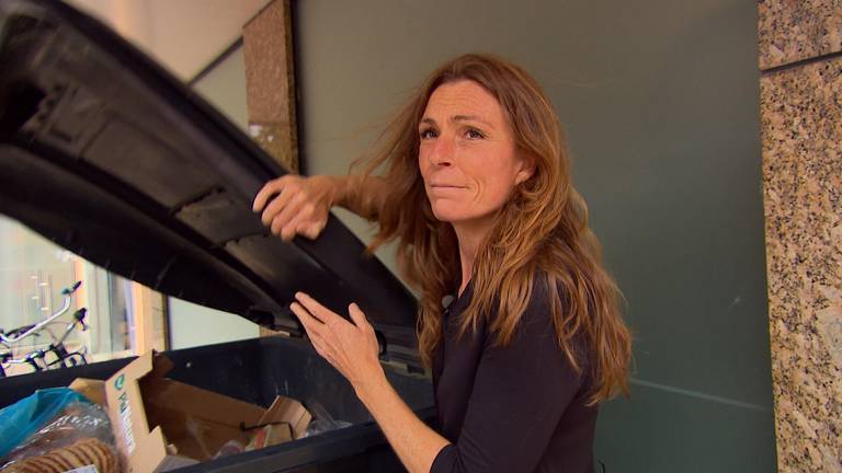 Femke at the wheelie bin where the groceries are thrown in (photo: Carlijn Kösters).