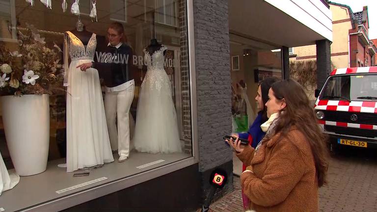 Thea geeft vanuit de etalage uitleg aan Nathalie en haar moeder Sylvia.