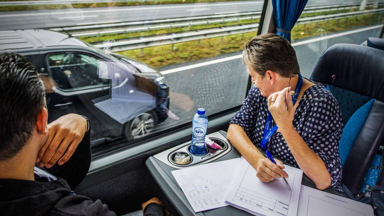 Vanuit een touringcar controleren agenten of weggebruikers een telefoon vasthebben (foto: ANP).