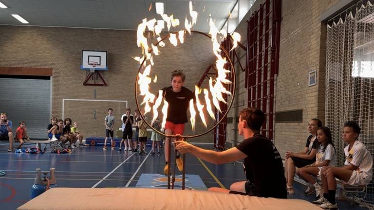 Kinderen springen door een brandende hoepel, tijdens een workshop van stuntman Lars Damink (foto: Niek de Bruijn)