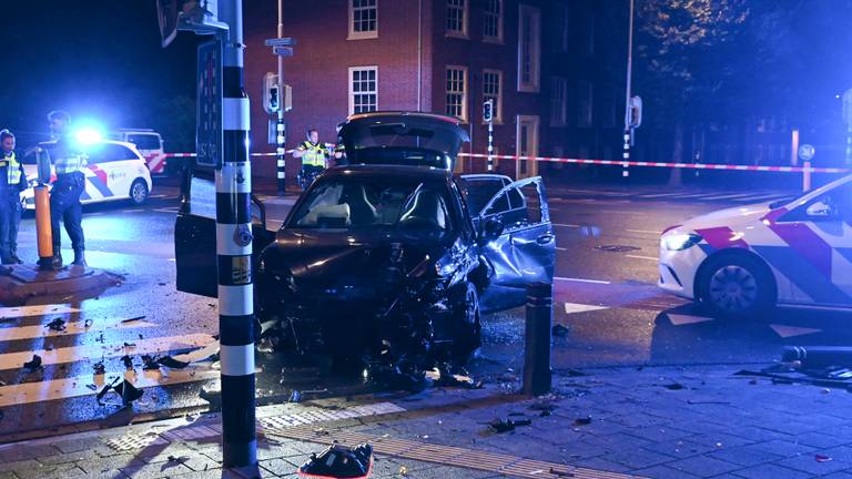 Auto crasht op kruising na politieachtervolging, weg vol brokstukken