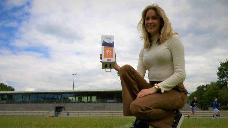 Lynn van Gils met een dispenser voor gratis zonnebrandcreme. (foto: Raoul Cartens)