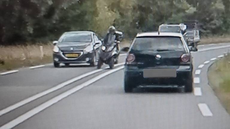 De bestuurder van de MP3 (midden) betrapt (foto: Verkeerspolitie Oost-Brabant).