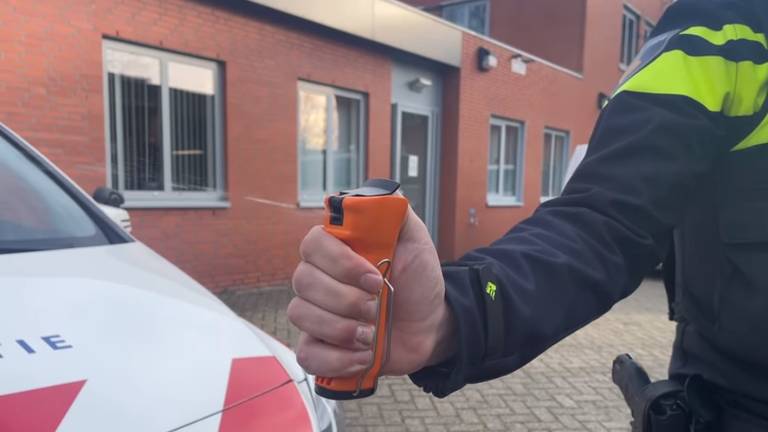 Een agent demonstreert de UV-spray (foto: Facebook politie Rooendaal).