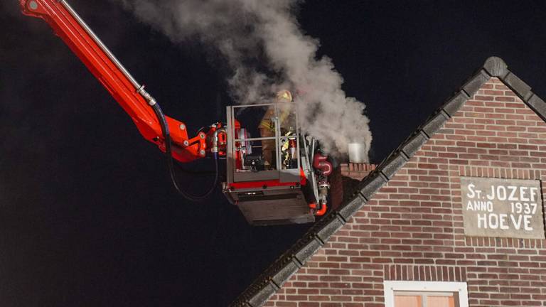 Vanuit een hoogwerker wordt in Someren een schoorsteenbrand bestreden (foto: Harrie Grijseels/SQ Vision).