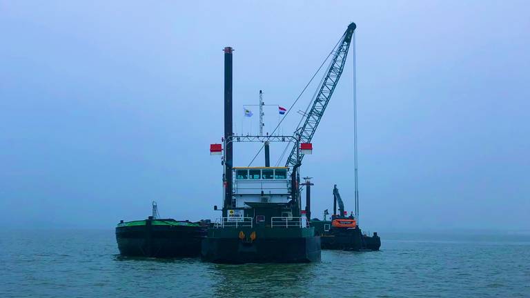 Met een schip en een ponton wordt de oude brandstofleiding opgevist (foto: Raoul Cartens).