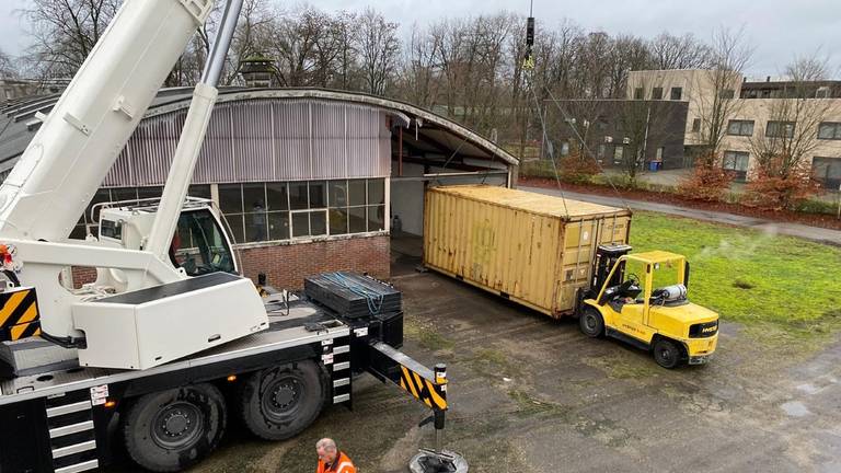 Een zeecontainer wordt geplaatst.