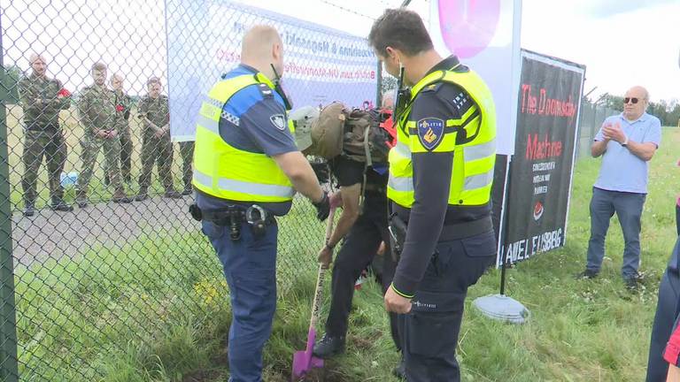 Demonstranten proberen gat te graven onder het hek van Vliegbasis Volkel