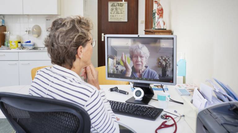 Een huisarts via een beeldverbinding in gesprek met een patiënt (foto: ANP).