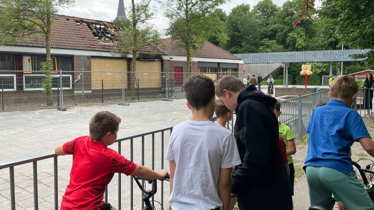 Inmiddels is de school met hekken afgezet en staan kinderen toe te kijken (foto: Rene van Hoof).
