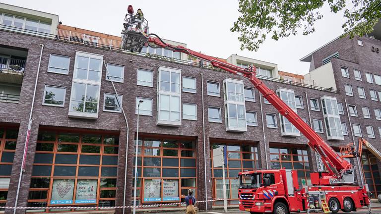 De brandweer verwijderde het loszittende deel van de regenpijp in Breda (foto: Tom van der Put/SQ Vision).
