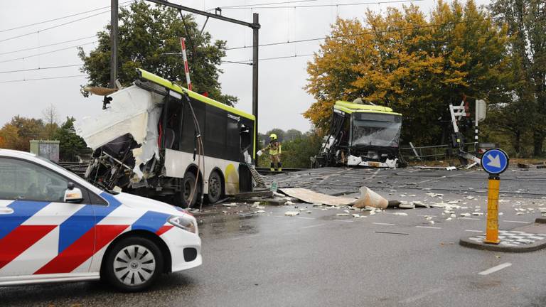 Bus doormidden na botsing met trein, ravage enorm 