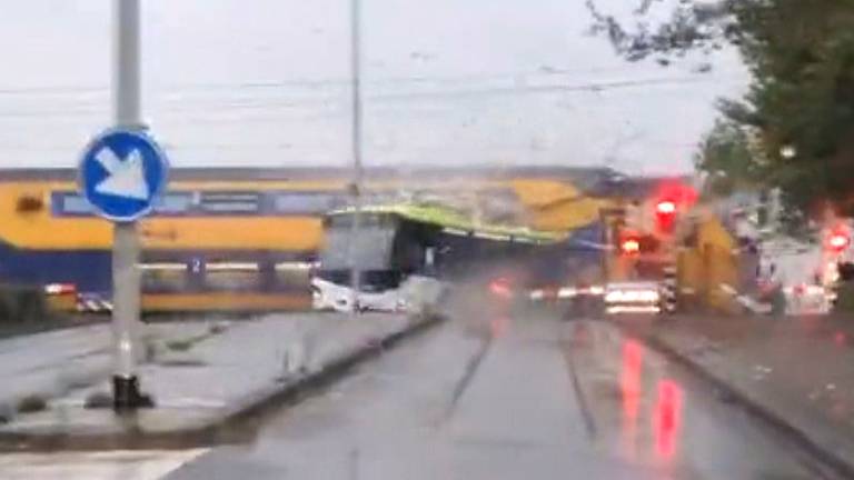 Het moment dat de trein de bus ramt op de overweg.