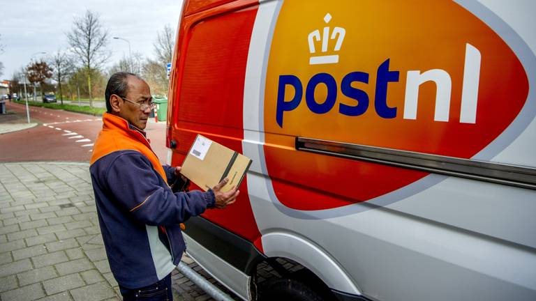 Een postbode van PostNL die brievenbuspakketjes aflevert (foto: ANP). 