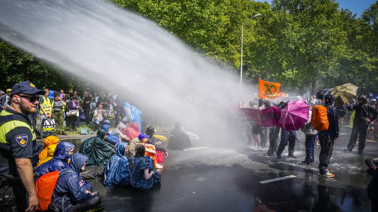 De politie zette een waterkanon in tegen activisten van Extinction Rebellion die de A12 in Den Haag voor de zevende keer blokkeerden. (foto: ANP 2023/Phil Nijhuis).