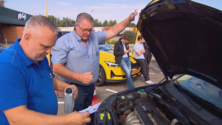 René (rechts) en een collega controleren onder de motorkap 