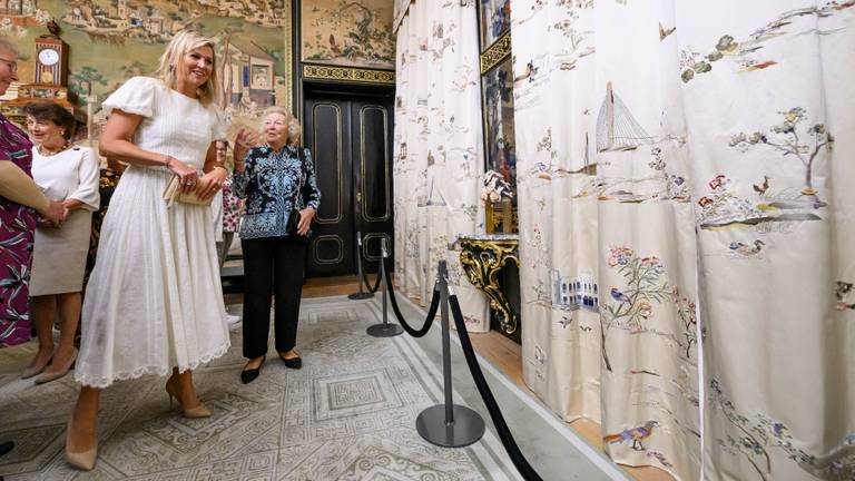Koningin Máxima en prinses Beatrix bekijken samen met de handwerkers de nieuwe gordijnen (foto: ANP/Patrick van Emst).