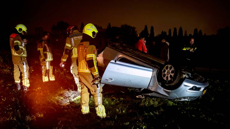 Auto belandt ondersteboven langs de weg (foto: Marcel van Dorst / Eye4Images).