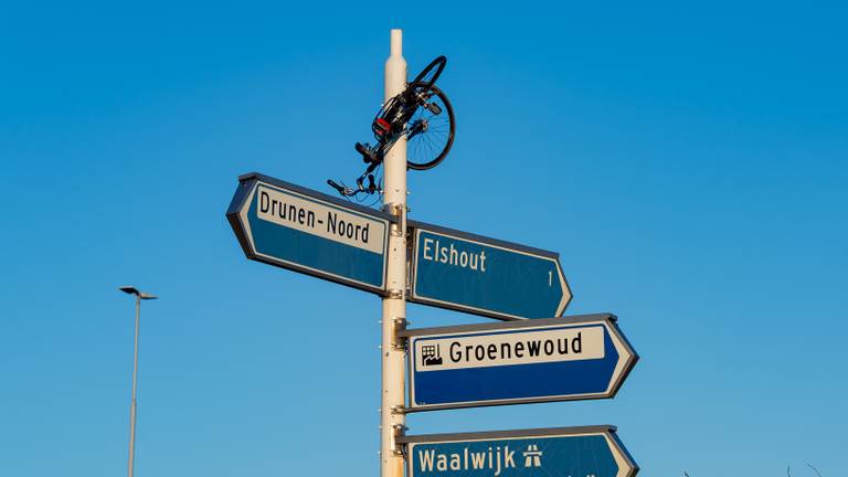 Fiets hangt boven in wegwijzerpaal en niemand weet hoe hij daar terechtkwam