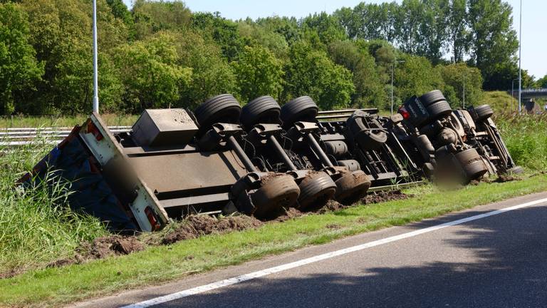 Vrachtwagen belandt op zijn kant in greppel langs A2