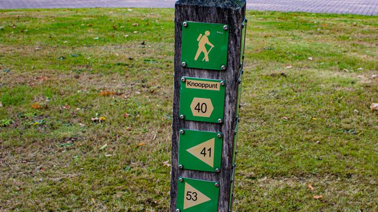 Een paal met pijltjes met verschillende wandelroutes in Tilburg (foto: Gijs Franken/Omroep Tilburg).