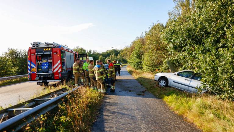 Vrouw raakt met auto van de weg en knalt tegen boom