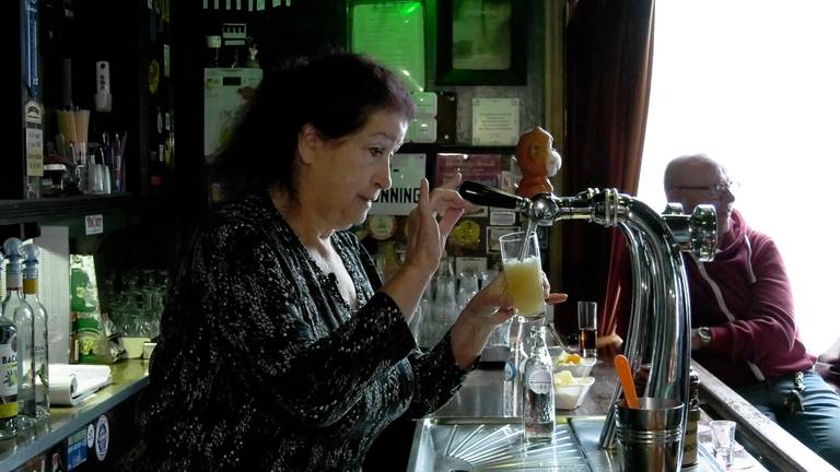 Hennie achter de bar bij haar café de Vredesduif (foto: studio040)