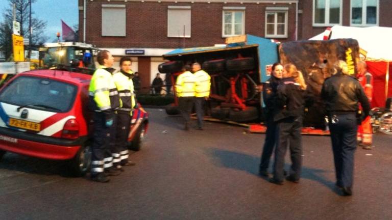 De omgevallen platte kar van de handballers op de rotonde in Boekel