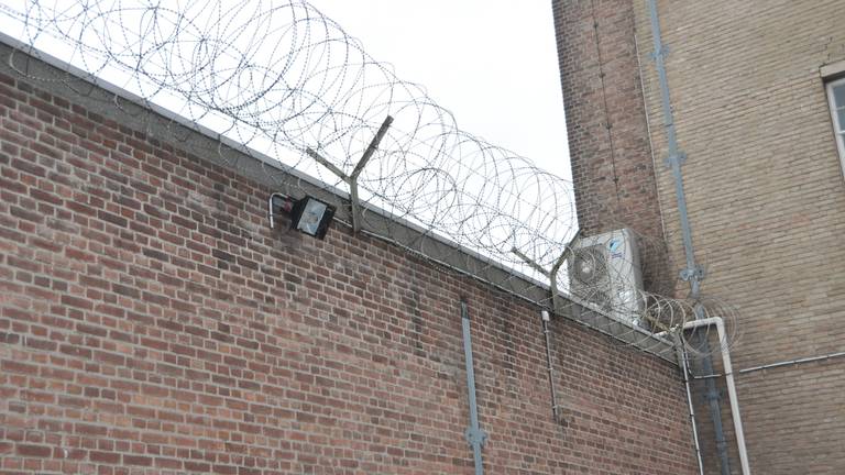 hoge muur met prikkeldraad op binnenplaats