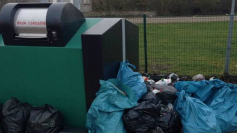 Schippers dumpen hun afval naast de afgesloten afvalbak