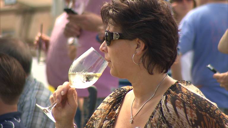 Met 'n glas witte wijn in de hand genieten van de polosport tijdens Pinkster Polo in Waalre