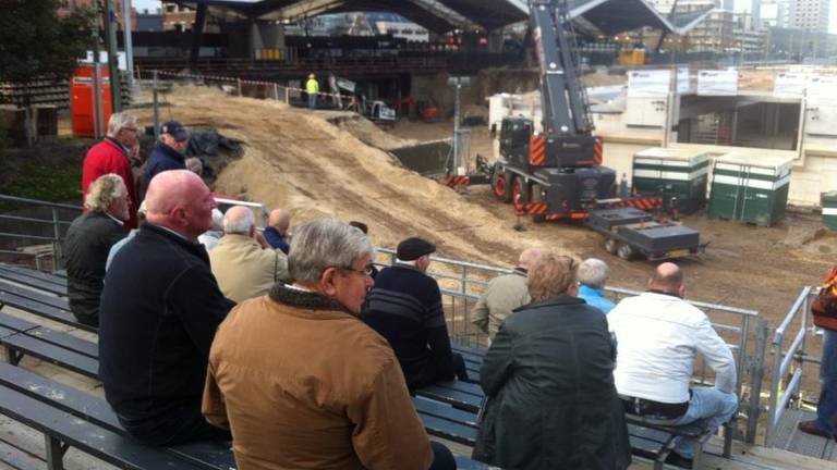 Verschillende mensen kijken toe bij het plaatsen van de tunnelbak (Foto: Erik Peeters)