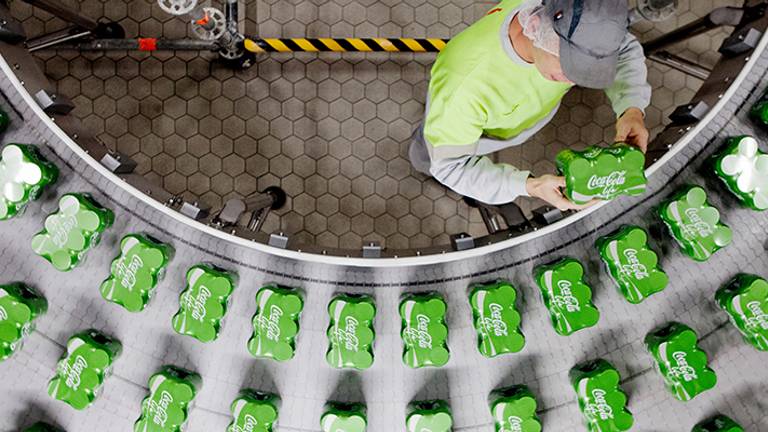 De nieuwe groene blikjes op de band in de fabriek in Dongen. Foto: Coca Cola