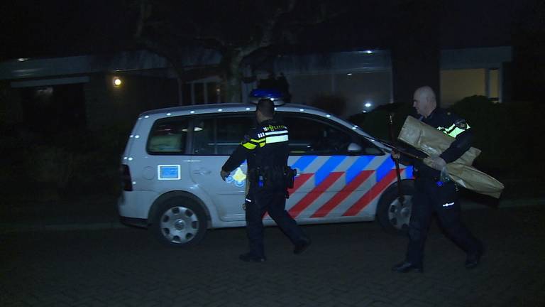 Politie brengt geweer naar buiten na inval
