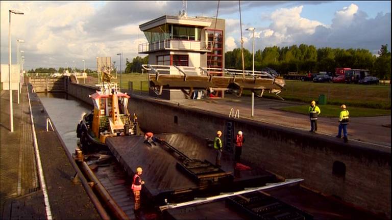 De deuren van de sluis komen per schip aan.