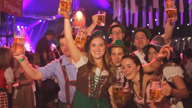 Oktoberfest-vierders in lederhosen en dirndl