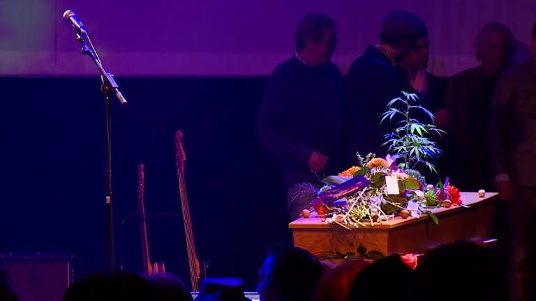 Bloemen en een wietplant op de kist van Armand naast de eenzame microfoon.