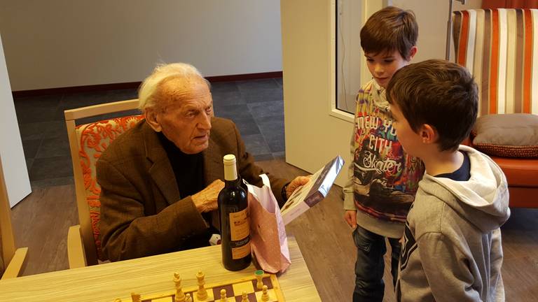 Wim Hendriks krijgt cadeaus van zijn achterkleinkinderen voor zijn 107e verjaardag. (Foto: Martijn v