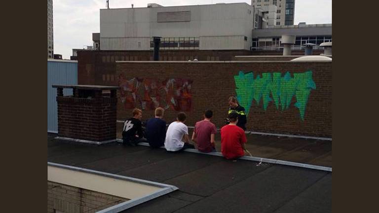 Het vijftal dat graffiti op de muur spoot. (Foto: politie Eindhoven/Facebook)
