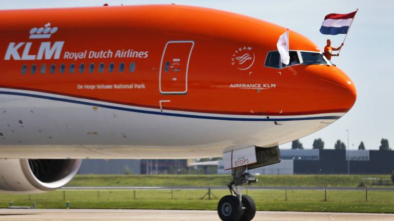 Ferry Weertman houdt de vlag vast bij aankomst op Schiphol (foto: ANP)