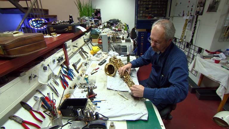 Johan van Geffen repareert een saxofoon