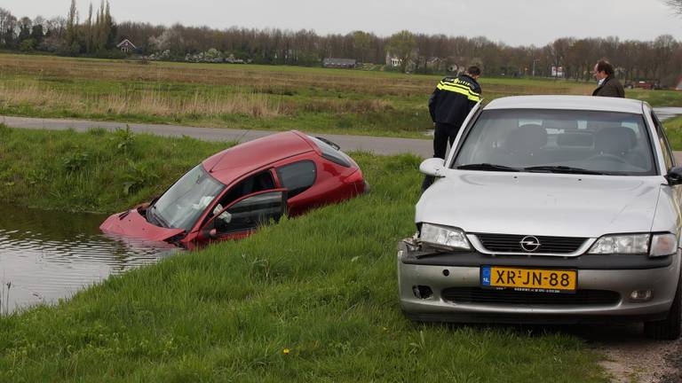 Na een botsing belandde een auto in Vlijmen in de sloot (Foto:FPMB Anja van Beek)