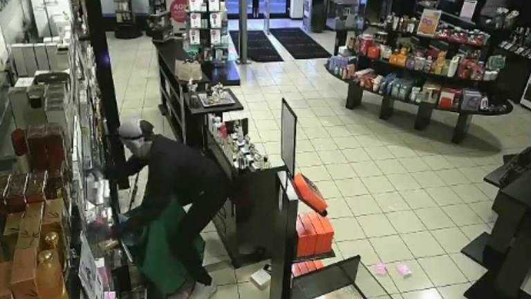 De dieven vullen hun tassen met parfum. (Foto: beeldstil video Facebook Politie Oss)