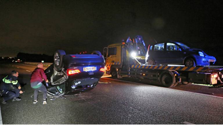 Een auto kwam op zijn dak terecht. (Foto: Remco de Ruijter)