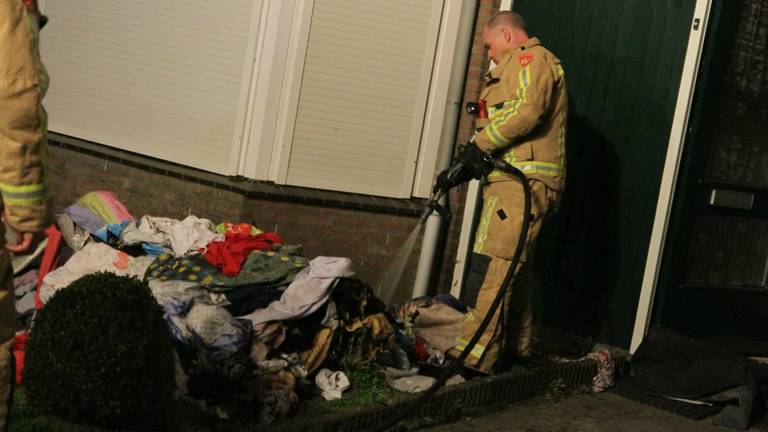 De brandweer blust kleren na een drogerbrand in de woning. (Foto: Pim Verkoelen/SQ Vision)