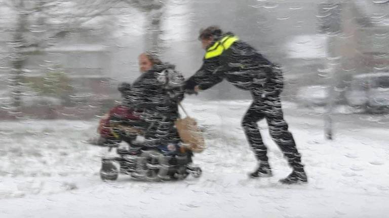 Een wijkagent schiet een vrouw in elektrische rolstoel te hulp. (foto: facebook Politieteam Markdal)